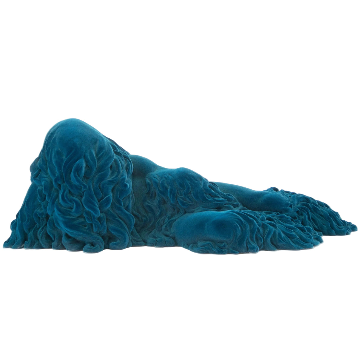 A sculptural teal blue figurine of a reclining form with flowing, wavy hair or drapery, shown against a plain white background.